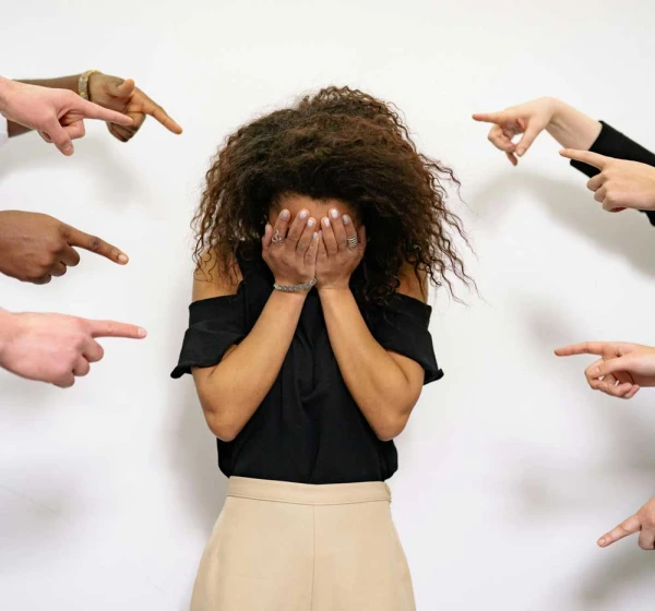 Vrouw met gezicht verborgen in handen en daar omheen wijzende vingers - therapie bij ZEON
